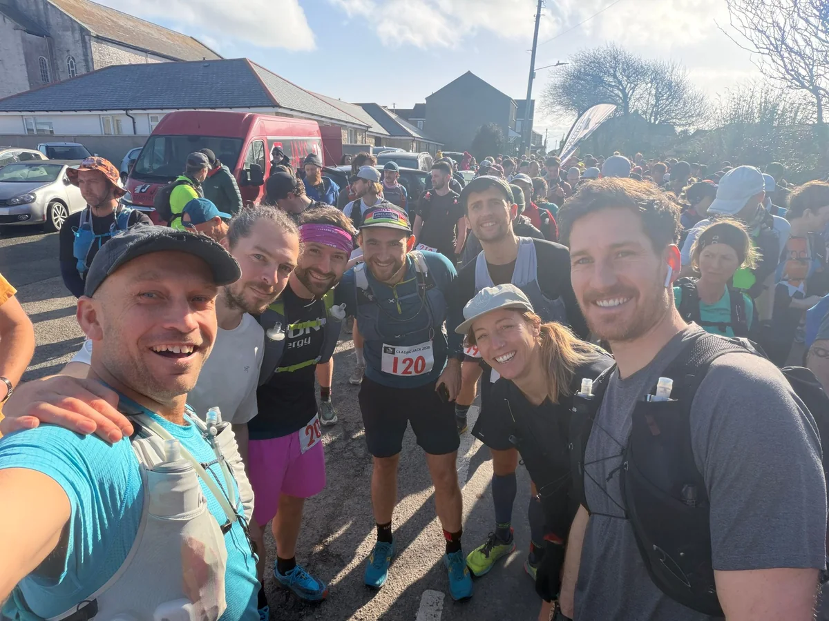 A group of runners packed together on the start line at St Just before Classic Jack, in low winter sun